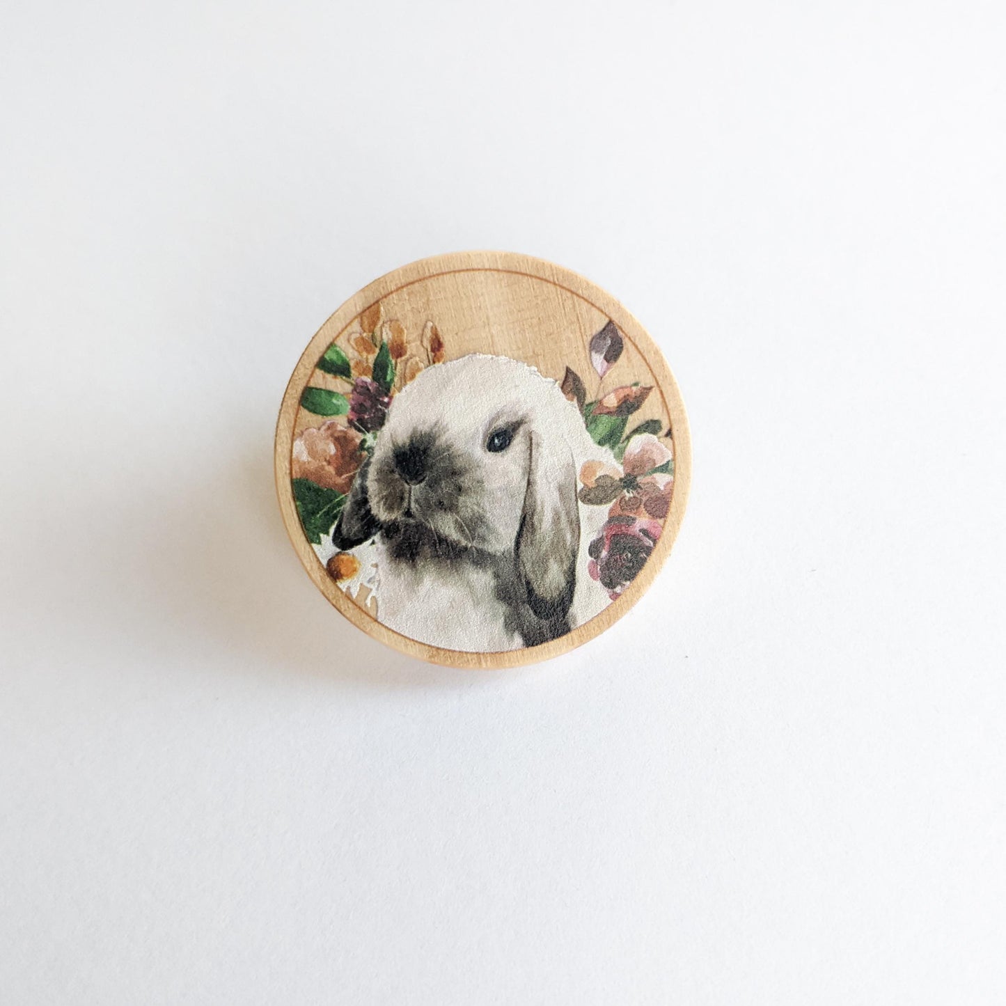 round wooden pin with a sable point holland lop bunny and flowers
