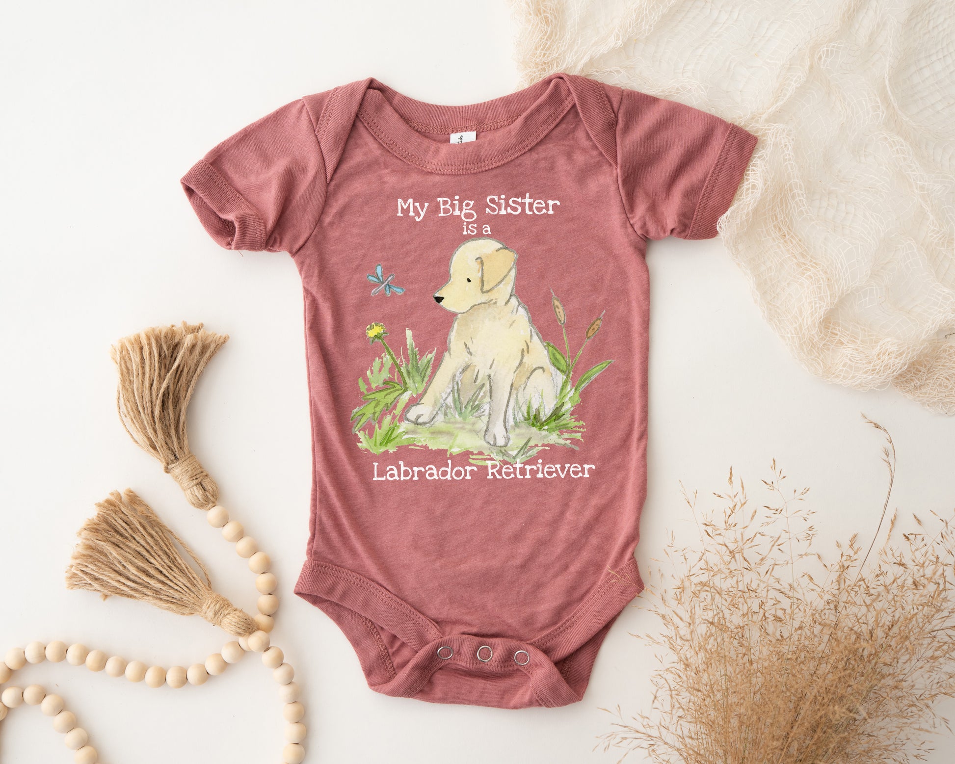 Baby onesie with a dog illustration and text on a light background