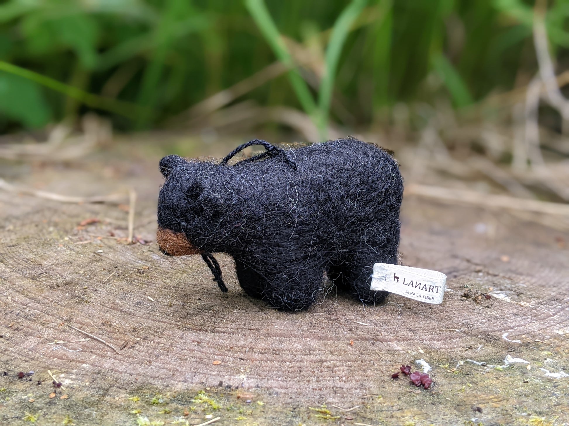 needle felted wool black bear cub sculpture standing on a log