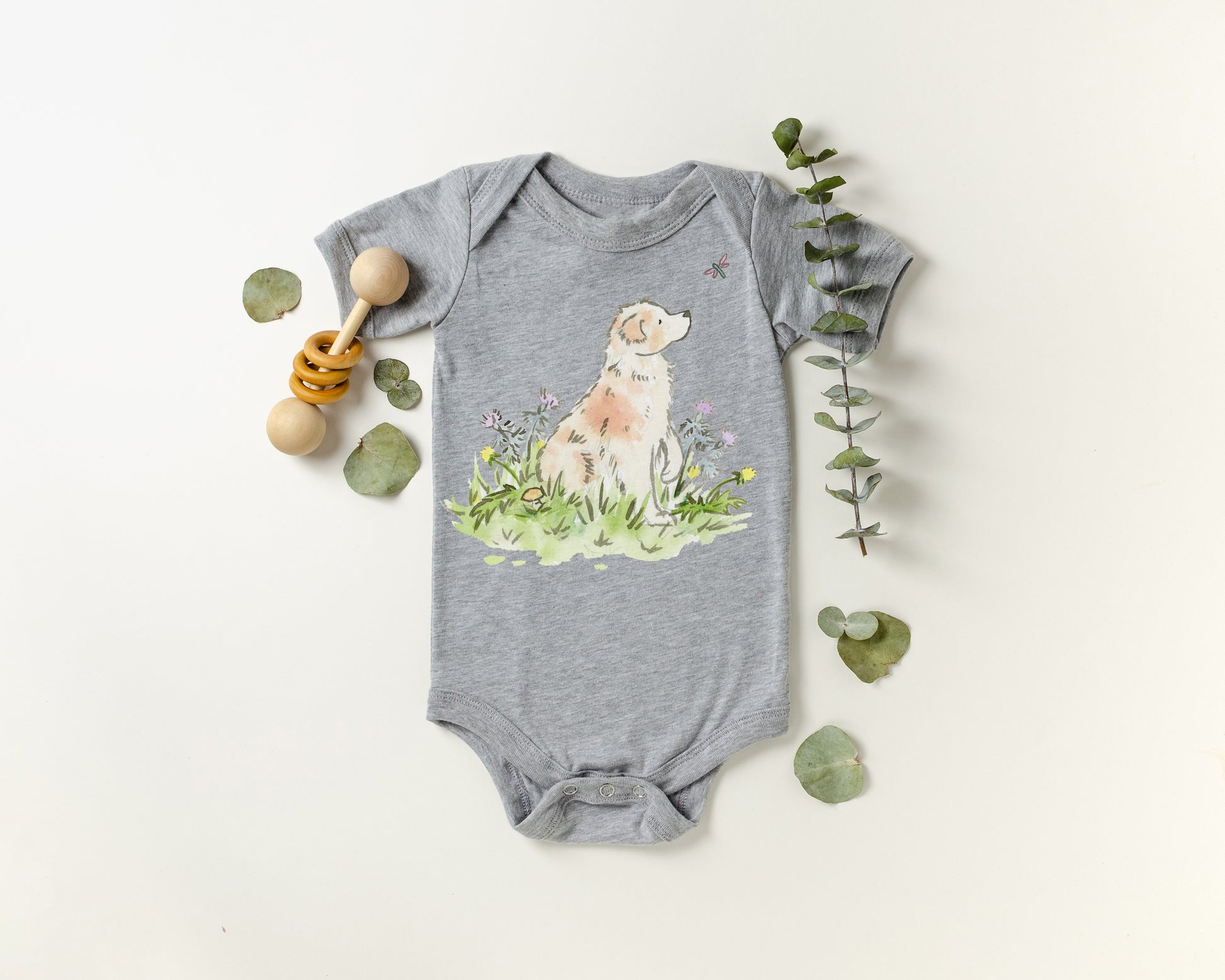 Gray baby onesie with a dog illustration on a white background