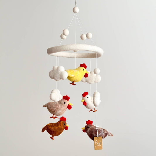 Children's mobile with colorful chicken figures on a plain background