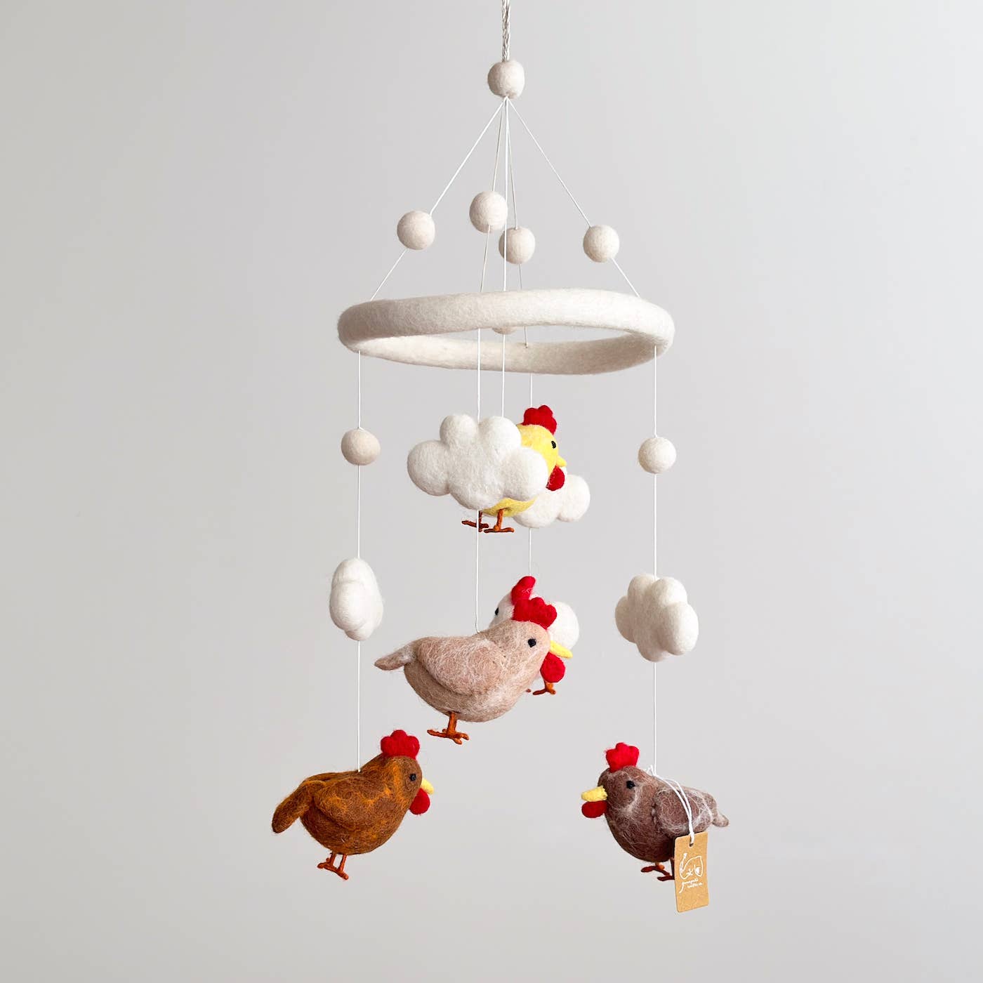 Children's mobile with chickens and eggs on a gray background