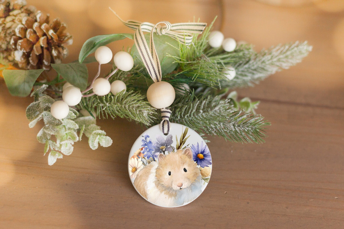 ceramic ornament with watercolor painting of cream and golden hamster and wildflowers