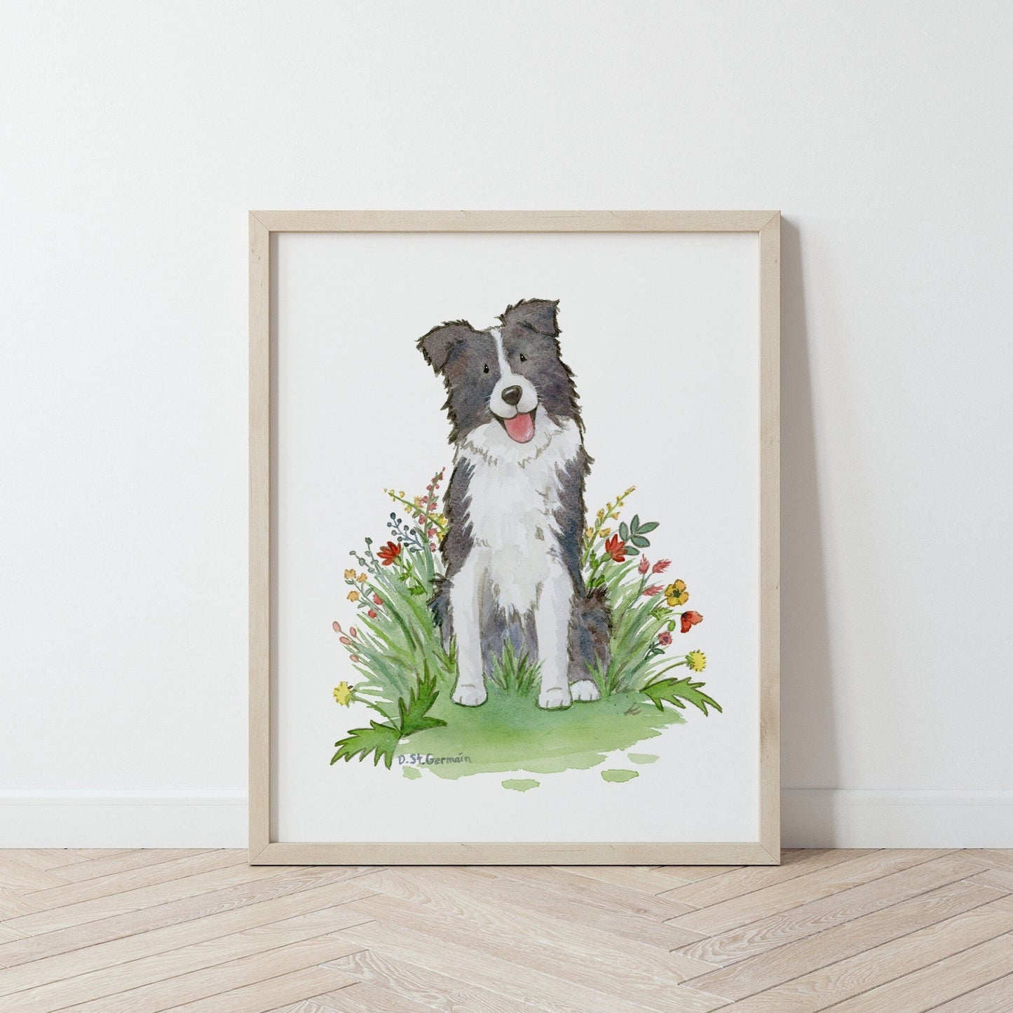 Framed print of a happy black and white border collie dog sitting in a patch of red and yellow wildflowers.