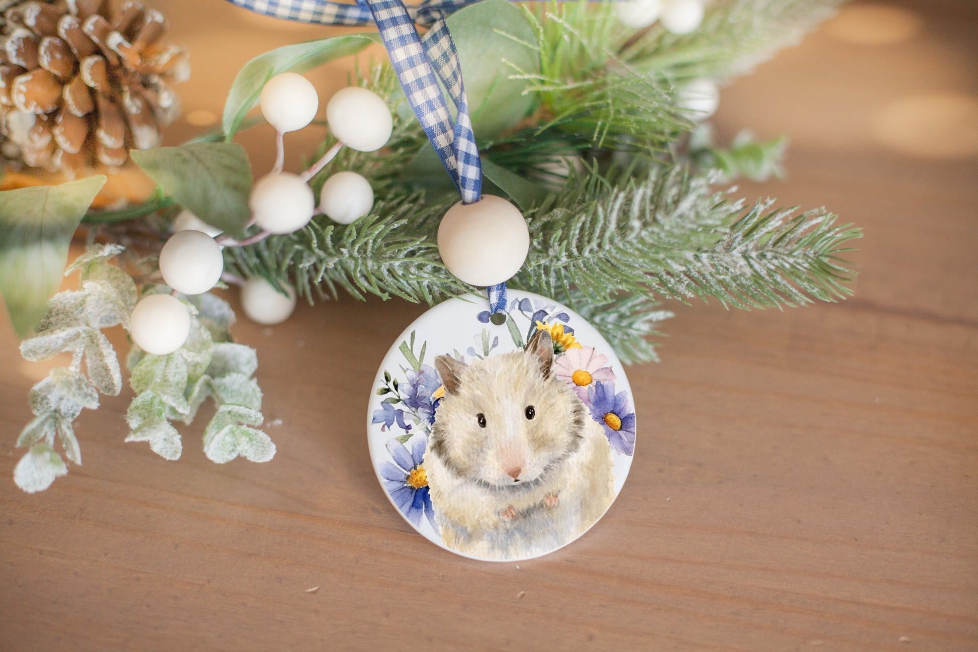 ceramic ornament with watercolor painting of cream and brown hamster and wildflowers