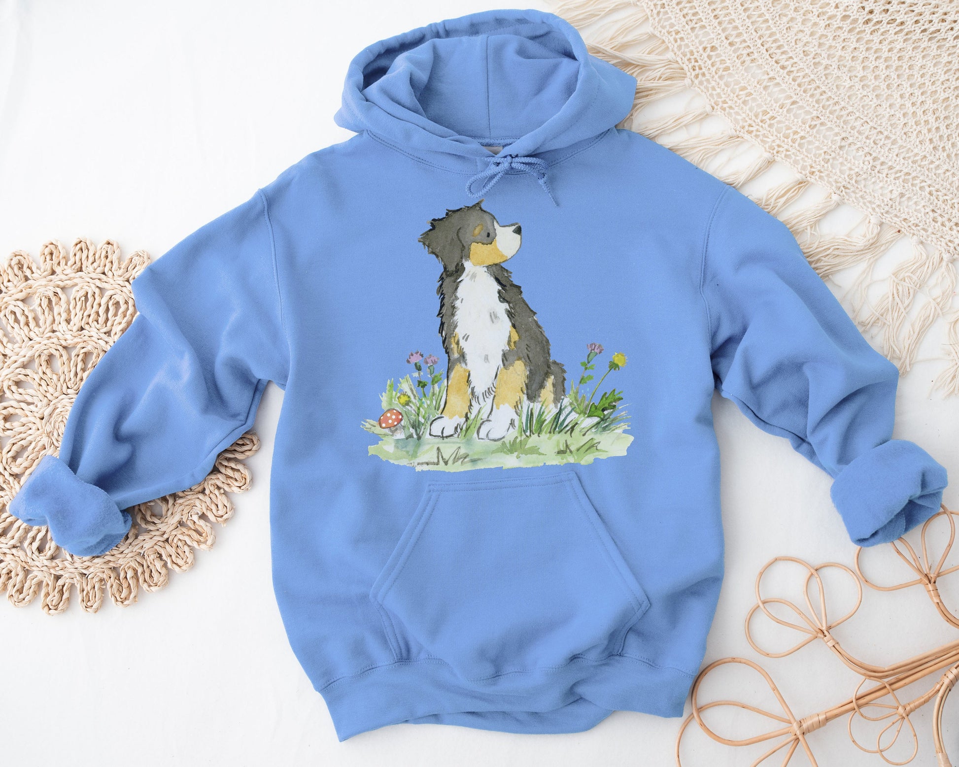 Light blue hooded sweatshirt with artwork of a Bernese Mountain Dog and Flowers on it.