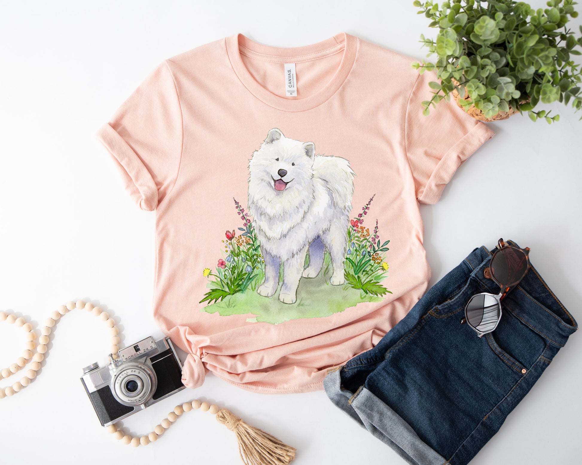 Peach t-shirt with cute, fluffy, white samoyed dog and colorful flowers on it.