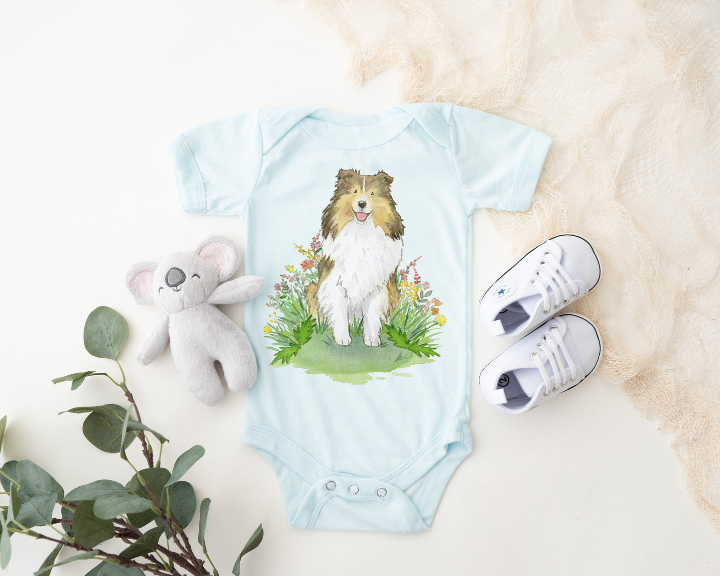 Baby bodysuit with cute sable sheltie puppy on it
